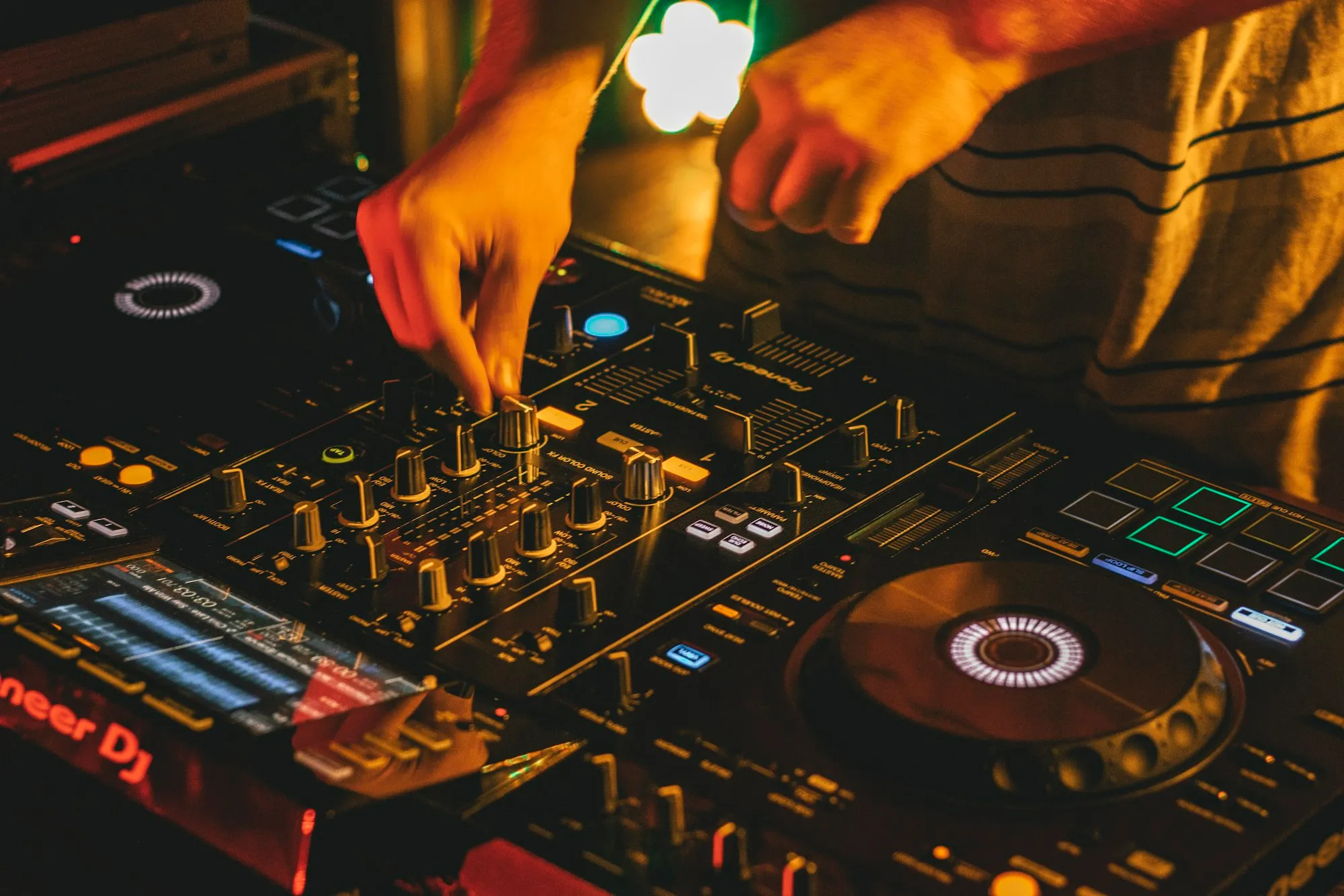 Mains d’un DJ sur une table de mixage
